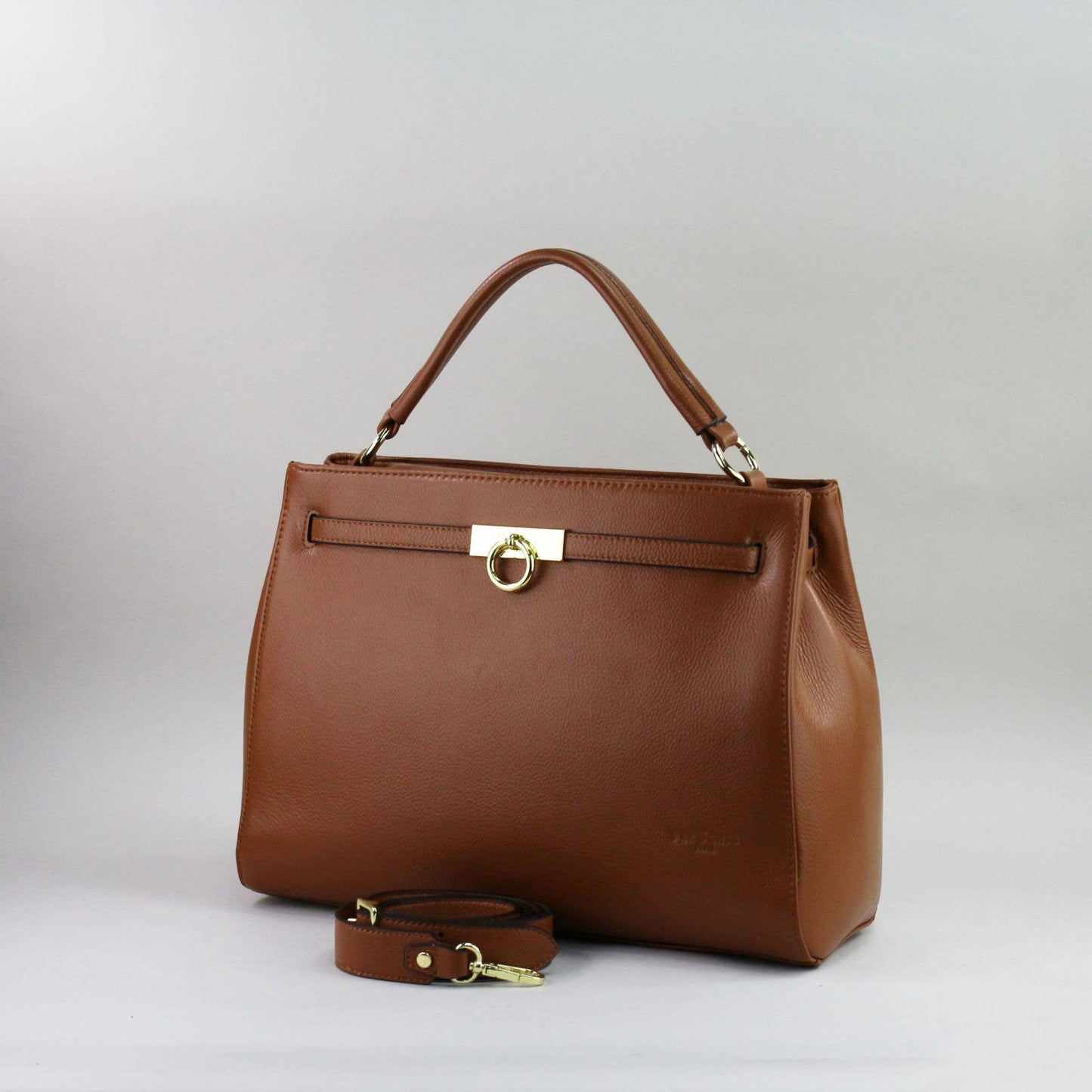 Brown leather laptop handbag with a matching strap on a light grey background