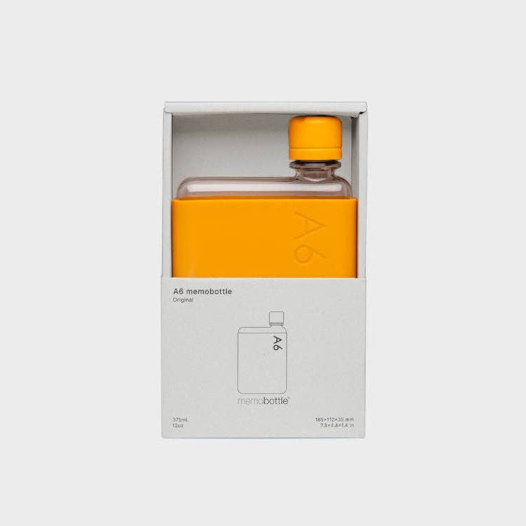 An orange colored A6 Memobottle with a stainless steel lid, designed to fit into handbags or pockets easily