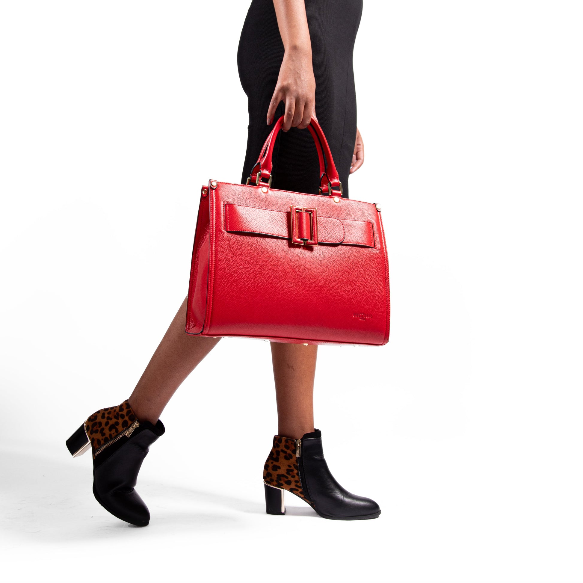Woman holding a red, leather, laptop handbag with a white background