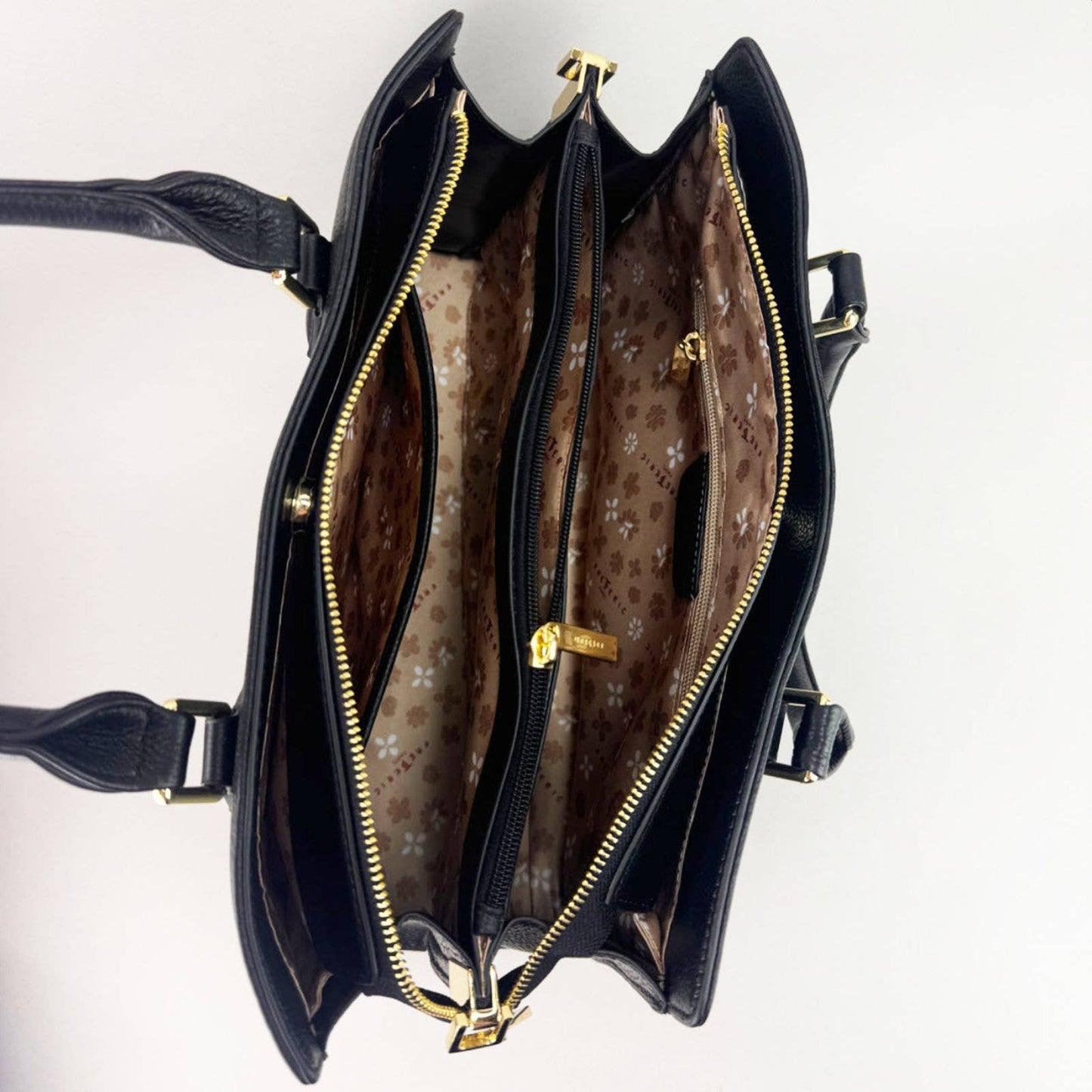 Open black leather laptop handbag with silver accents on a light grey background