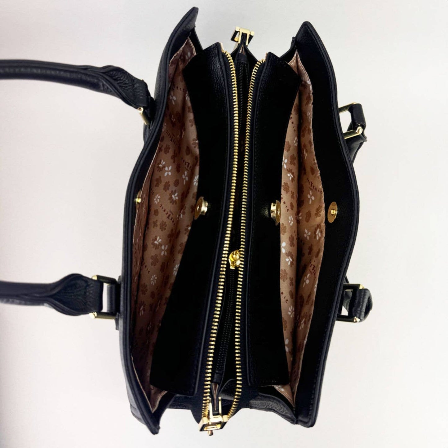 Open black leather laptop handbag with silver accents on a light grey background