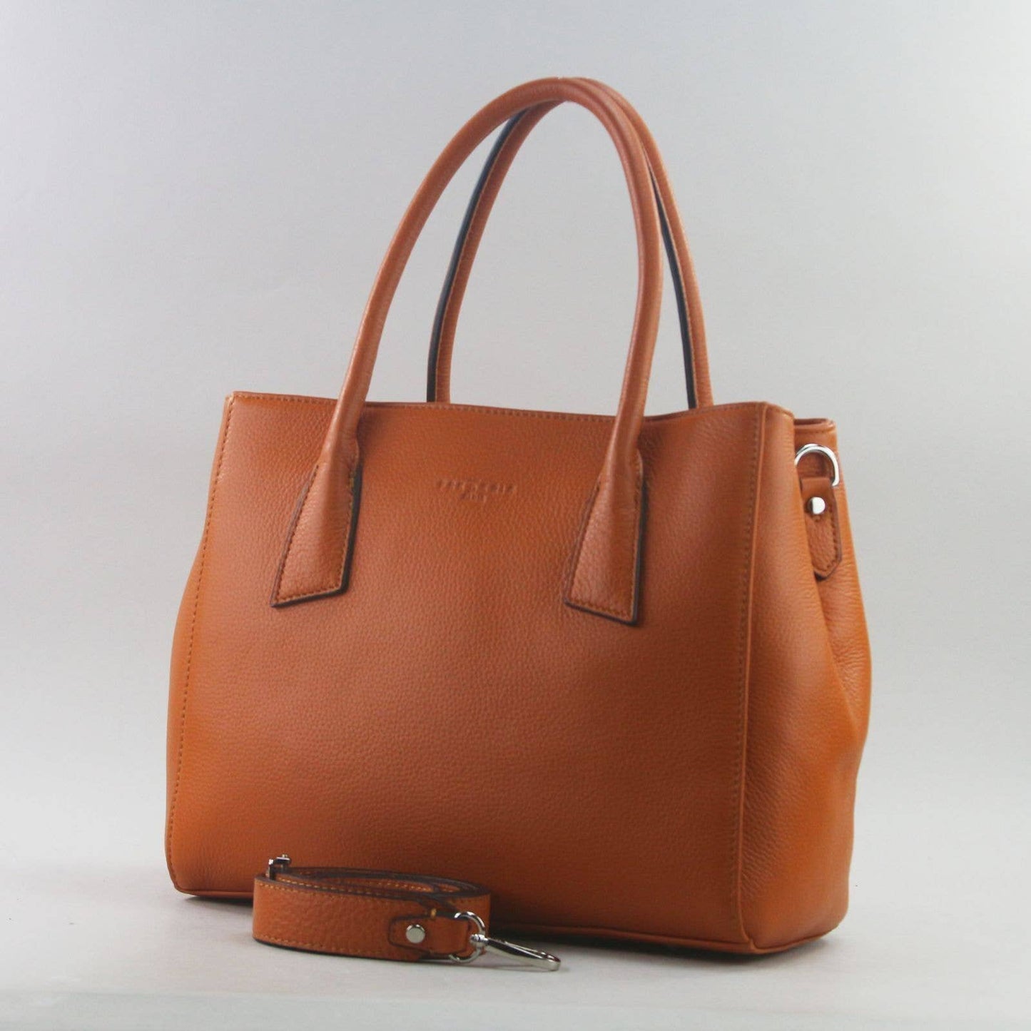 Orange leather laptop handbag with a matching detachable strap on a light grey background