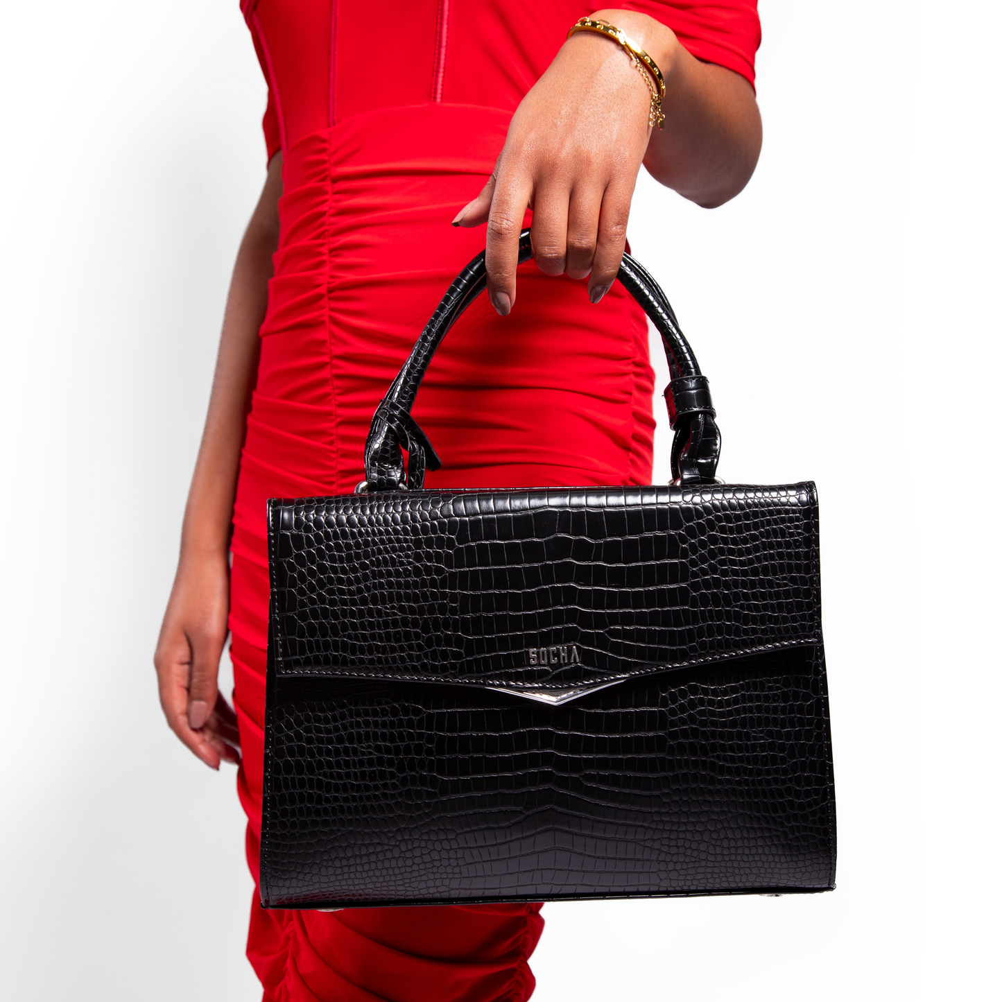 Person holding a black laptop handbag with a red dress